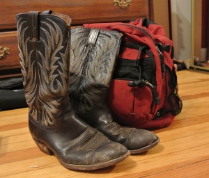 Cowboy boots next to a red bag