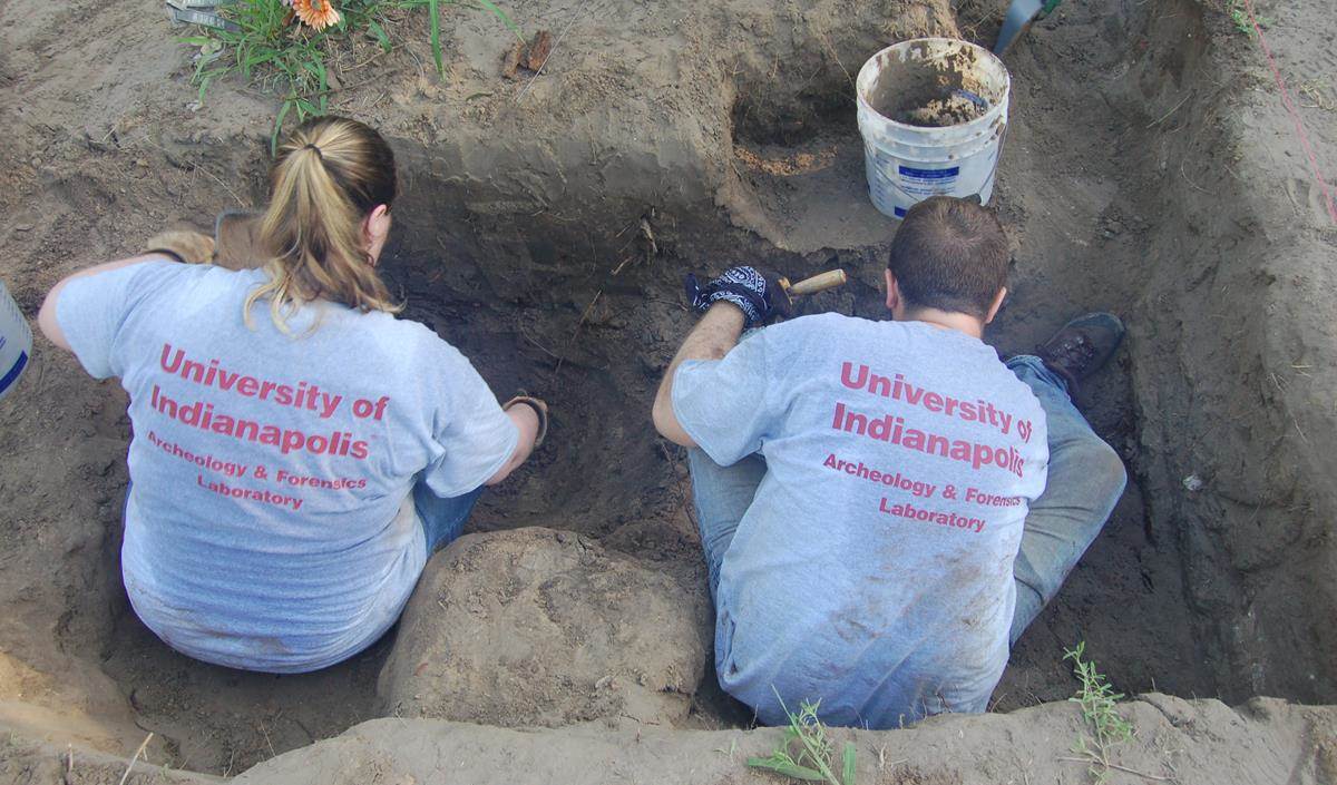 Two UIndy team members working in a burial