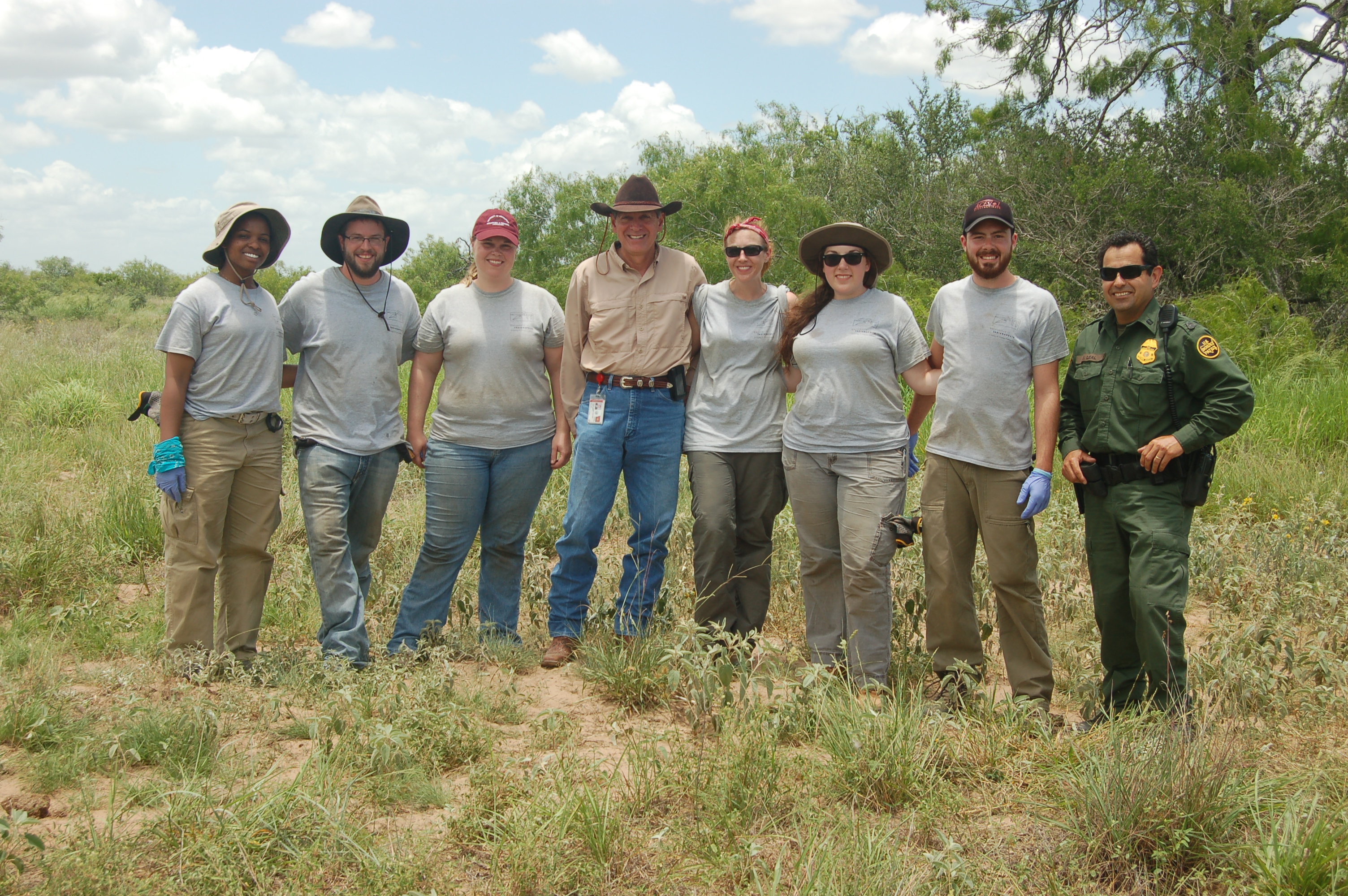 Uindy team smiling with a border patrol and authority persons