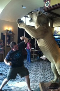 Justin striking a post under a large stuffed cat