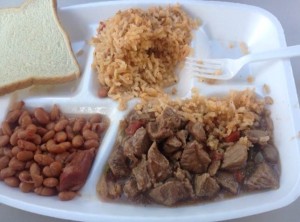 Styrofoam plate of beans, meat, rice, and bread