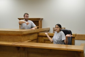 Justin and Amanda sitting in the judge and witness stand acting out the part!