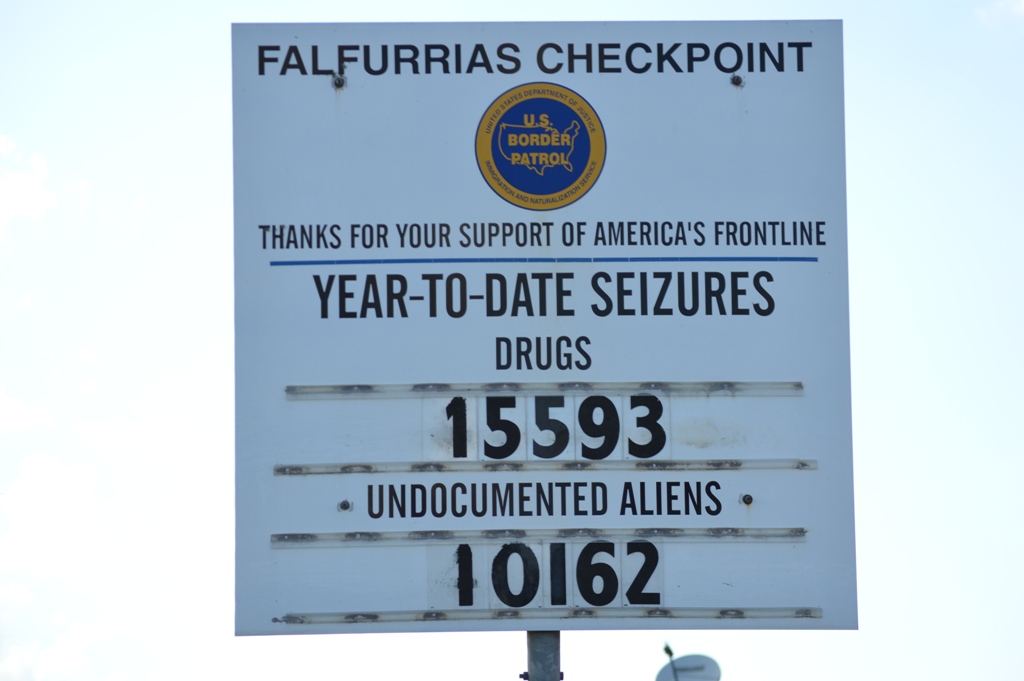 Falfurrias checkpoint sign stating year-to-date seizures of 15,593 drug seizures and 10,162 migrant seizures