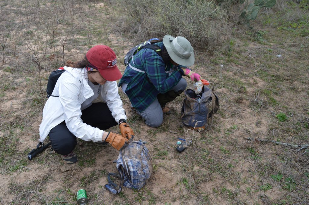 Team members going through discarded backpacks