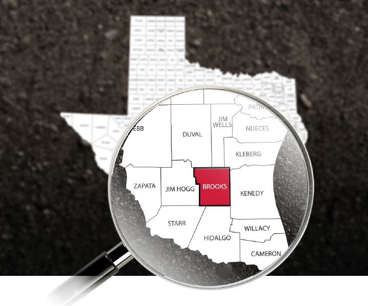 A map of Texas with a magnifying glass over the southern border counties and Brooks Co highlighted in Red