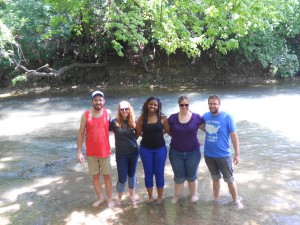 Group picture all standing in the river with no shoes on