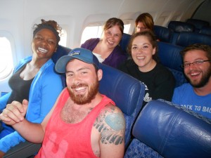 Team picture all in their seats on the plane