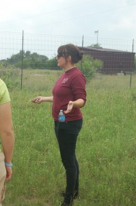 Hailey standing in a field giving an explanation with a visible fencing in the background