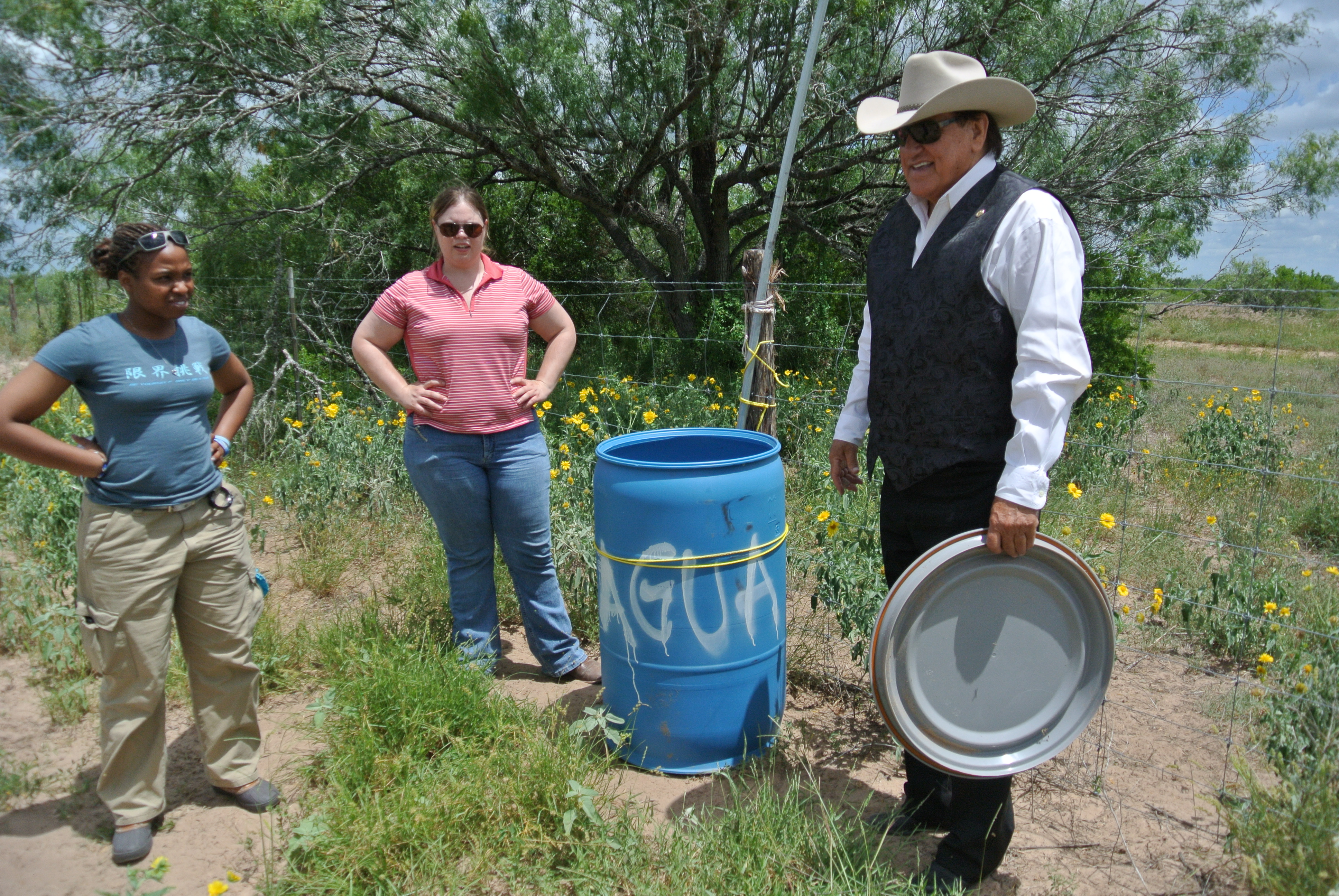 Lavoyger with two UIndy students at a water barrel 