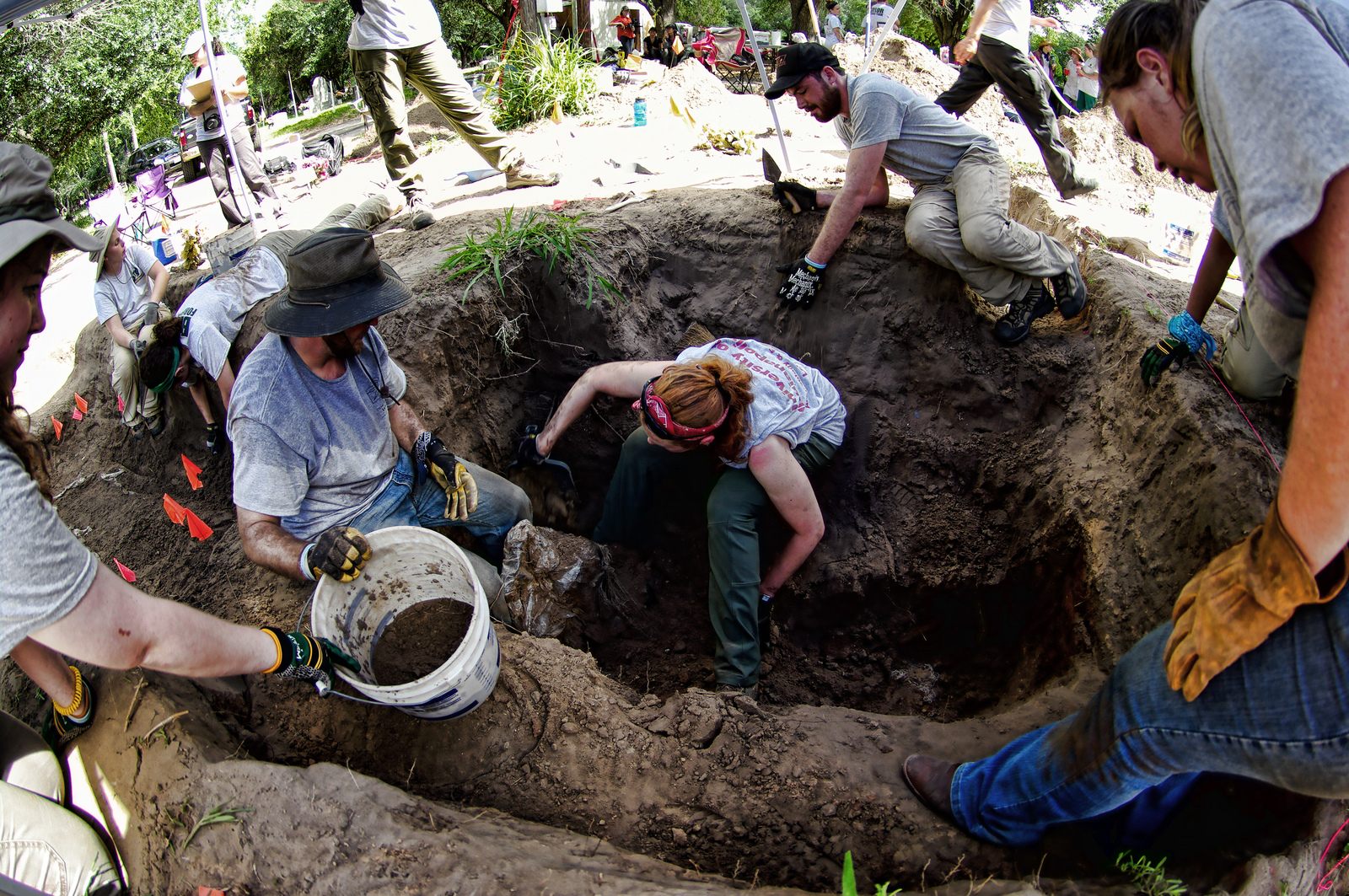 Team members working within a burial and from the ground surface