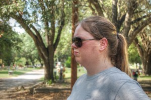 Jessica looking into the scene with sunglasses and a pensive look.