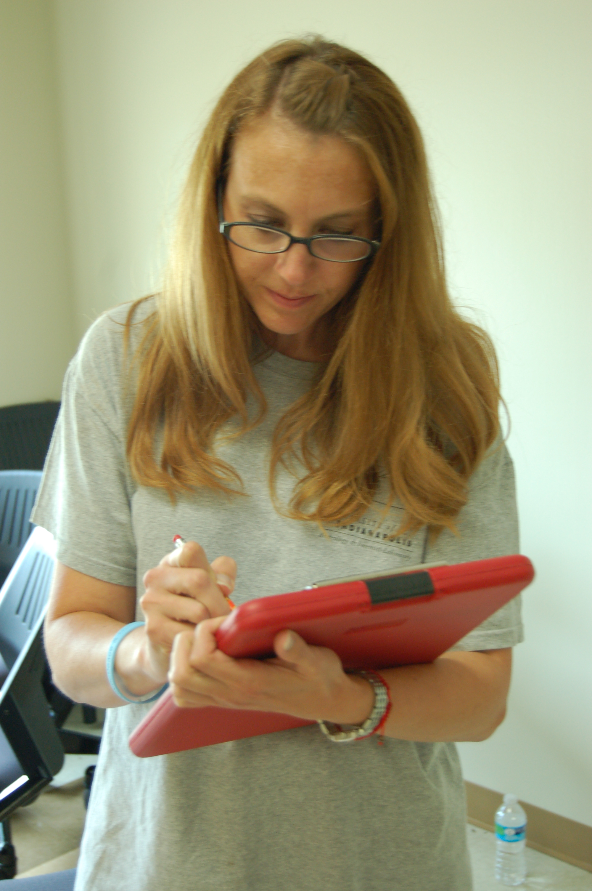 Dr. Krista Latham writing notes on a red clipboard