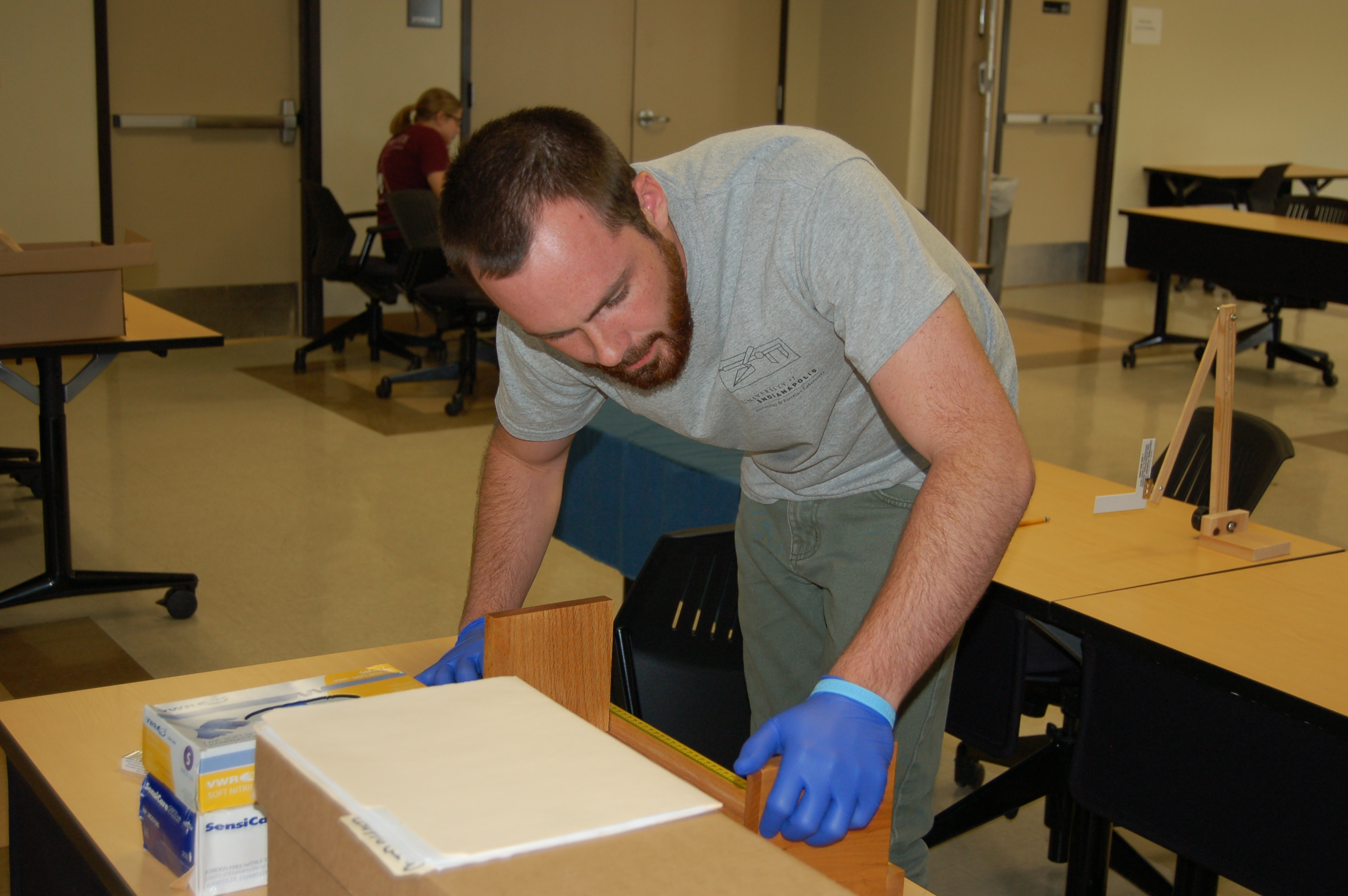 Team member Ryan performing measurements of skeletal elements on an osteometric board