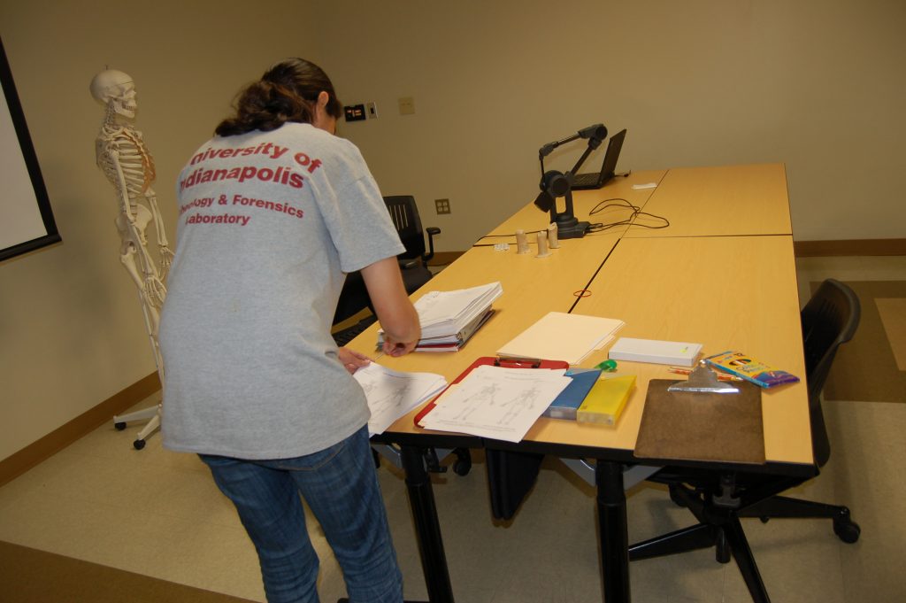 UIndy student setting up some paperwork on an open table