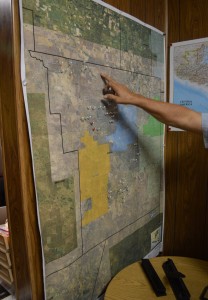 Map of Brooks County with the water stations marked with pins with an individual pointing at the map