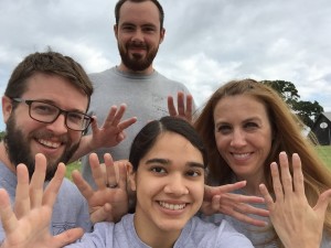 Group photo of Beyond Borders team members with nine fingers in the air on day 9