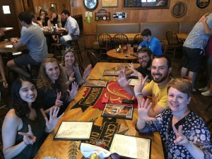 Group picture of Beyond Borders team members holding up 7 fingers for day 7 while at a restaurant