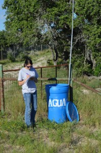 UIndy student writing data on a paper next to a water station