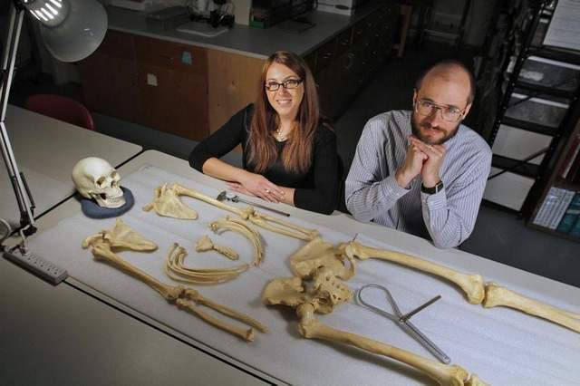 Dr. Krista Latham & Dr. Stephen Nawrocki with a skeleton laid out in anatomical position on the table in front of them