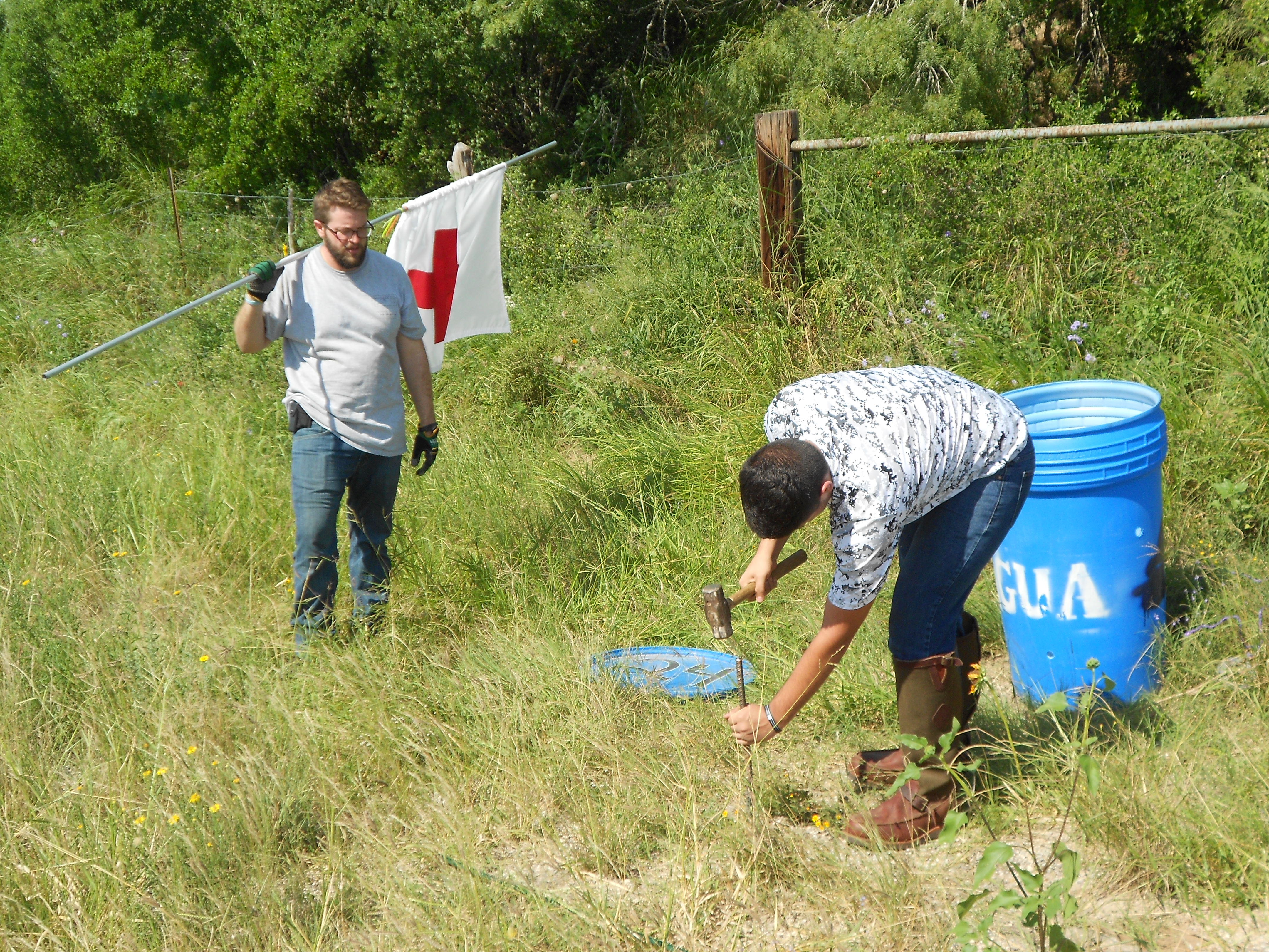Justin and another volunteer repairing a water station.