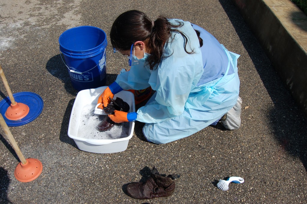 Team member cleaning personal effects in a small tub