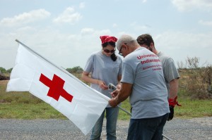 Three team members with a red cross flag