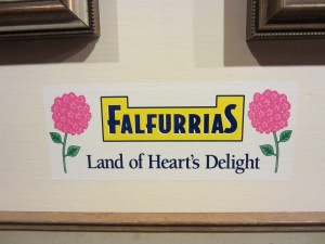 Falfurrias sign with pink flowers and "Land of Heart's Delight" written beneath it