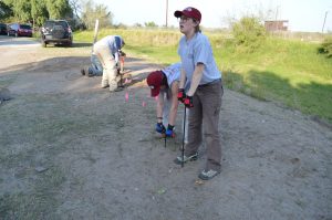 Team members using t-probes in the soil