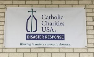 A poster for Catholic Charities USA Disaster Response Working to Reduce Poverty in America