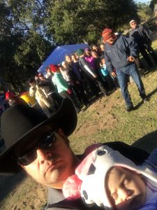 A man and a young child in front of a group of people