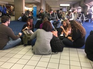 A group of people sitting on the floor.