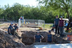 Texas State team members around a pit.