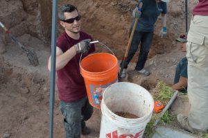 Dr. Goche moving a bucket of dirt.