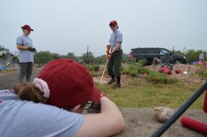 Team members using a tape measure to map.