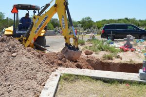 A backhoe filling in the pit.