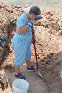 Sister Pam helping dig a trench.
