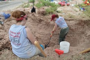 Haley excavating as Dr. Latham watches.