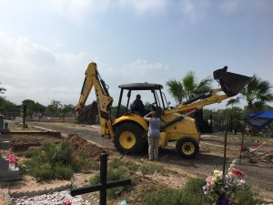 Silvestre talking to the backhoe operator at the cemetery.
