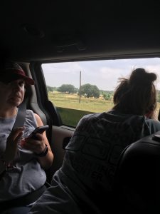 two team members looking out the minivan window.