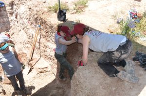 Team members helping each other out of the pit.