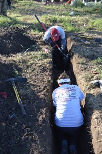 Two team members digging a trench.