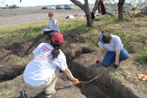 Three team members mapping in trench locations.