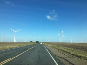 Driving down country highway with blue skies.