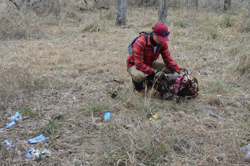 Team member looking through a discarded backpack