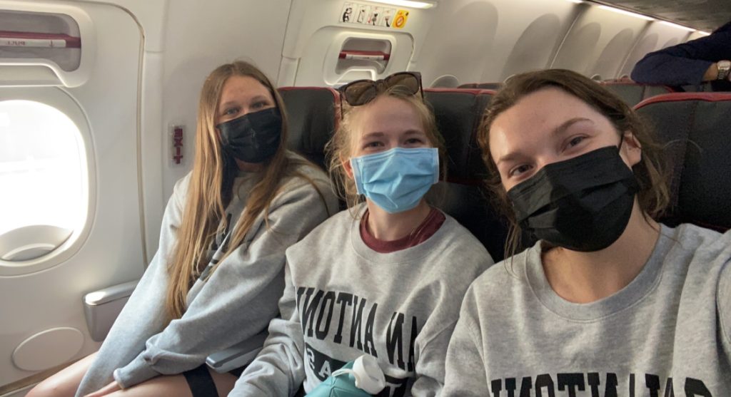 Three team members on the airplane during the May 2022 trip
