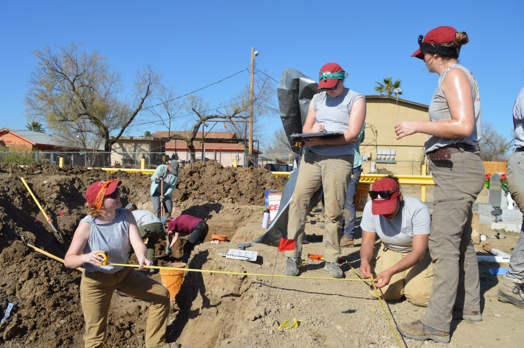 Team members taking measurements at the cemetery 