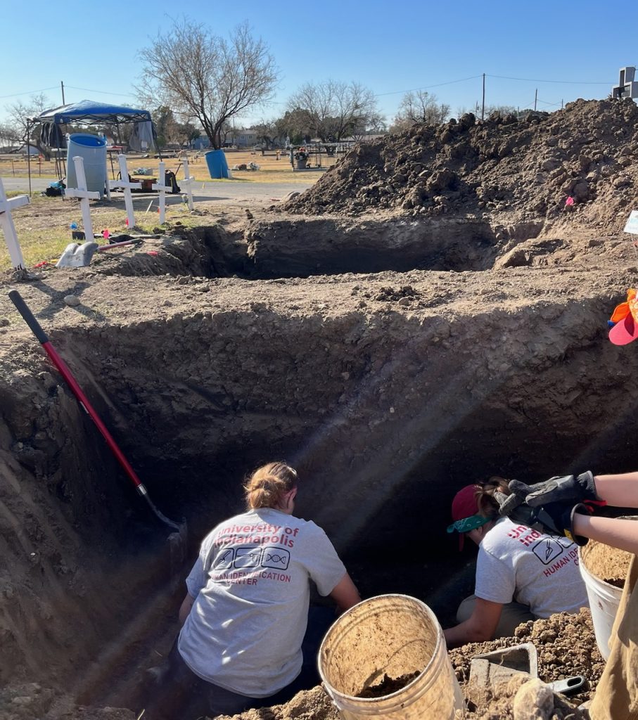 Team members removing dirt from a burial