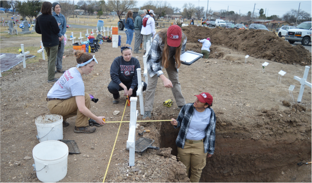 Team members taking measurements at the cemetery 