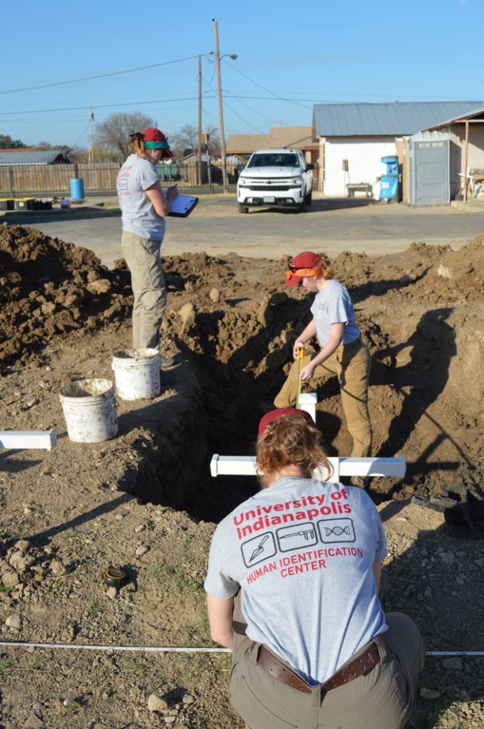 Team members taking measurements at the cemetery