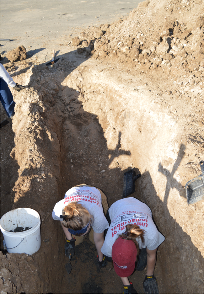 Two team members removing dirt from a burial